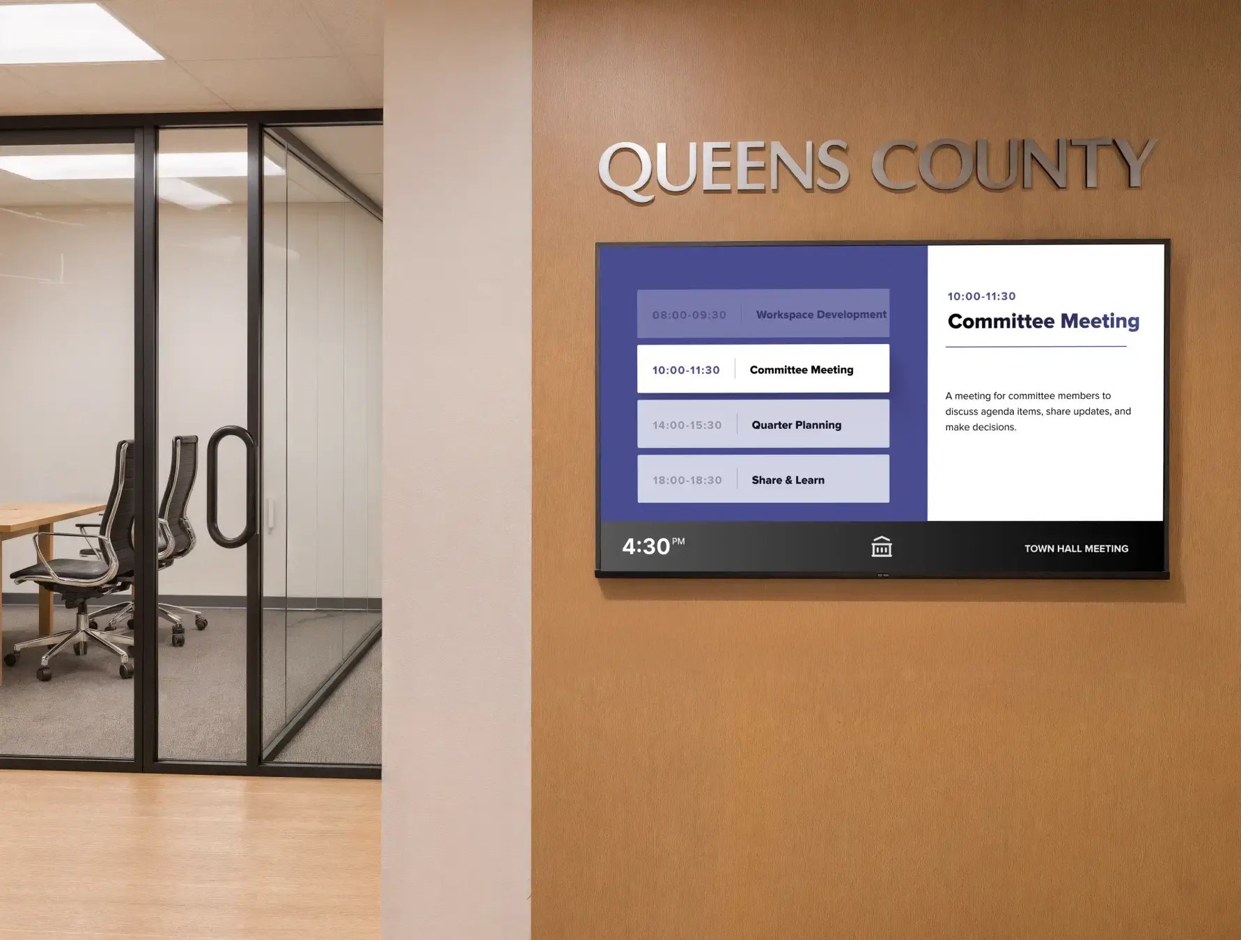 Qeens County digital signage on a wall near a conference room