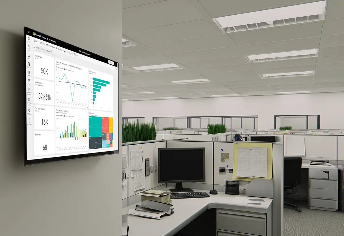 Office cubicles in the background with a TV display in the foreground mounted to the office wall