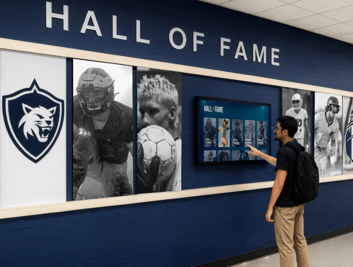 A male university student interacting with a digital hall of fame display