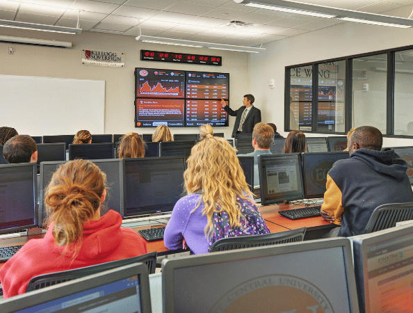 Students in a financial literacy lab learning about the stock market with large Rise Vision displays