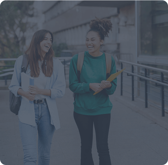Two females walking on campus laughing-1