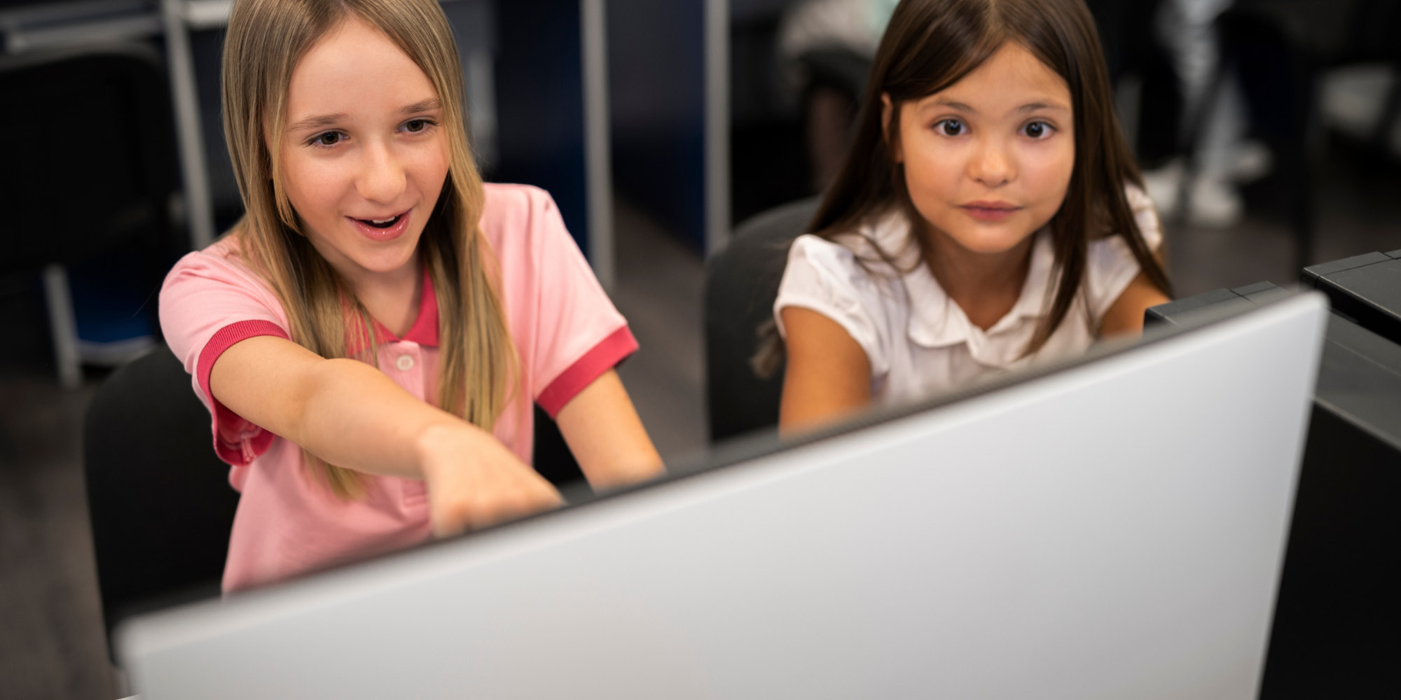 Two girls in schools are using screen-sharing technology.
