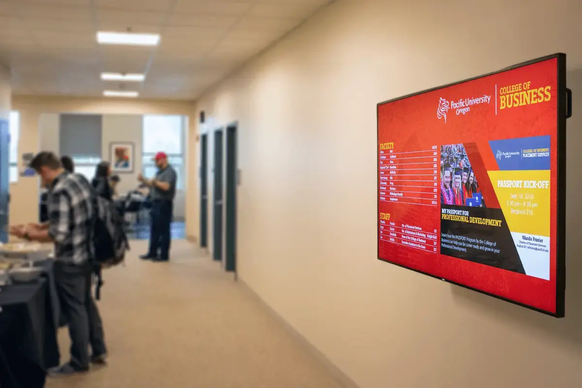 Higher education workers inside a building with a Rise Vision mounted display band digital signage