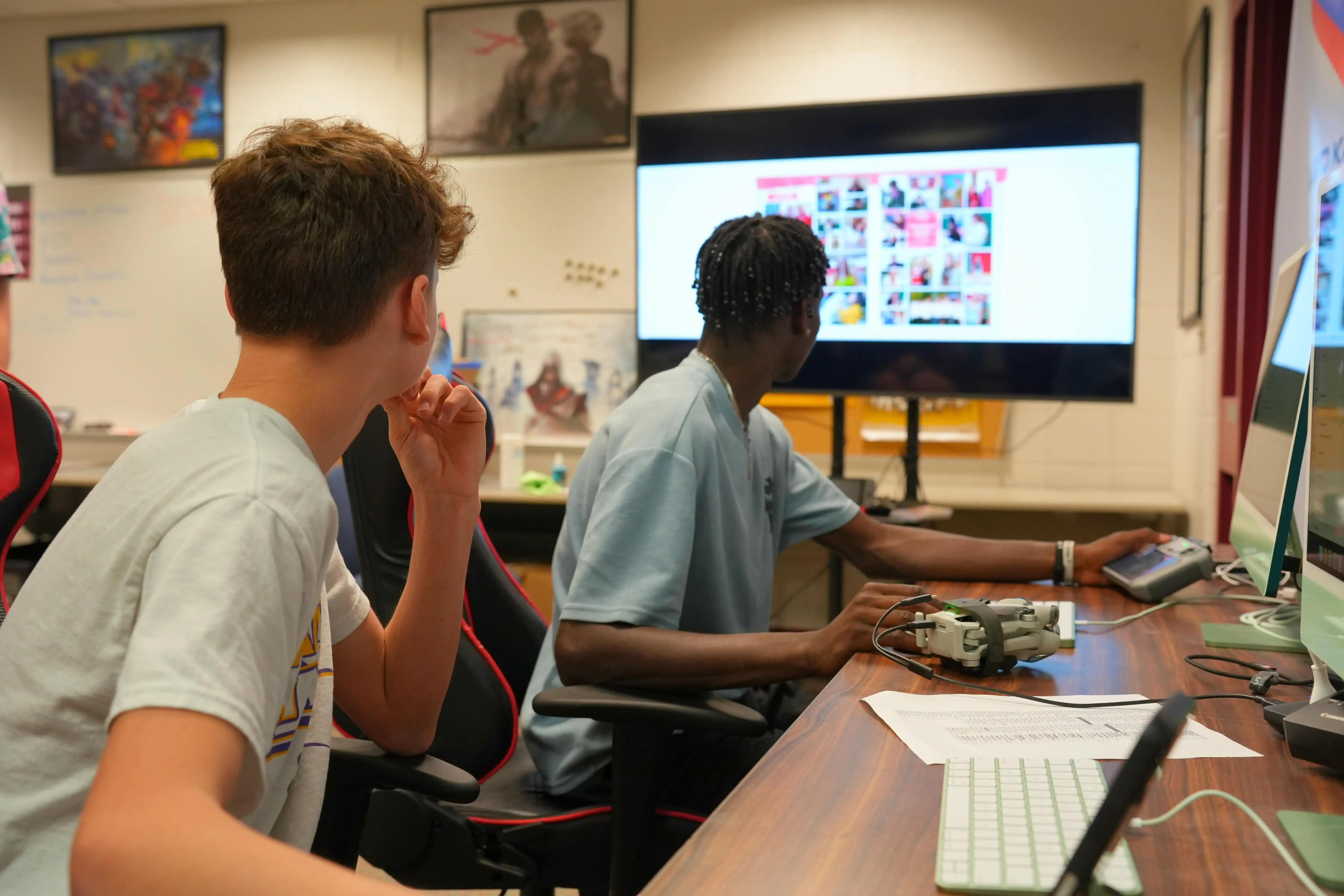 Two young men viewing a Rise Vision digital signage display in a classroom setting