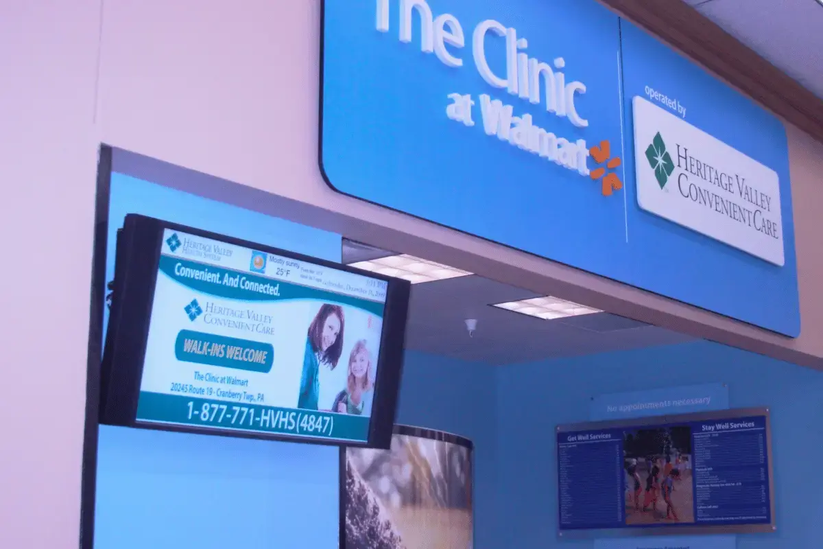 A digital signage display on the wall of a clinic at a Walmart