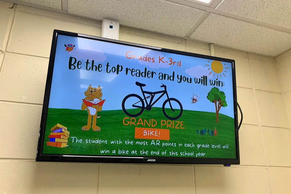 A large TV with digital signage display in a school wall for Grades K-3