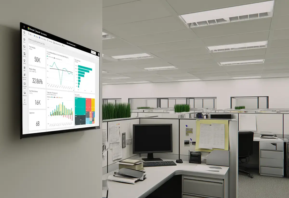 Office cubicles in the background with a TV display in the foreground mounted to the office wall