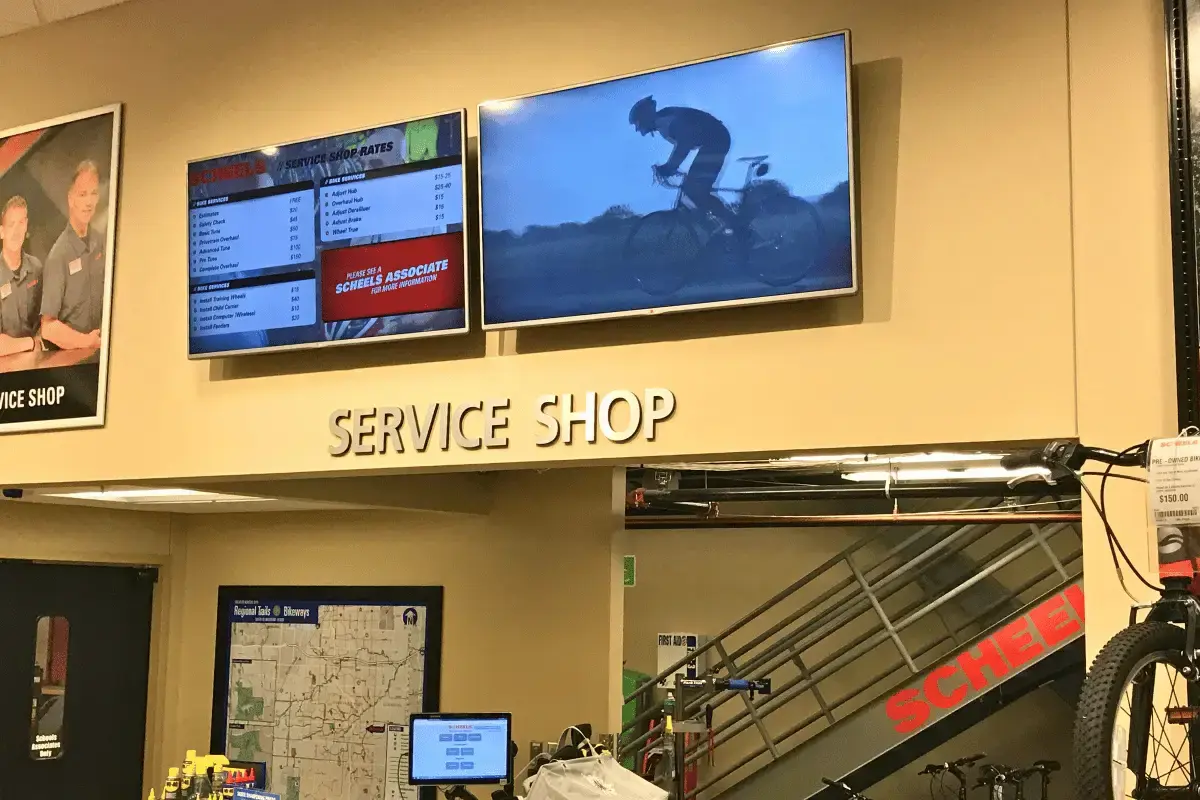 Two large digital displays above a service shop lobby
