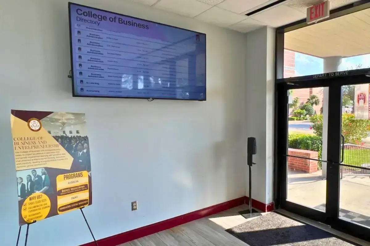 The inner lobby of a college campus with a digital display mounted on a wall