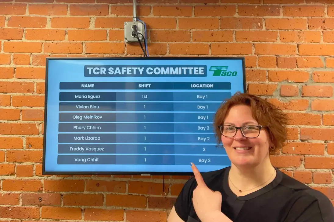 A femae standing in front of a digital display about TCR Safety Committee